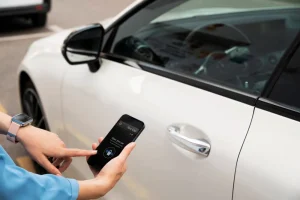 Person hält Smartphone vor weißem Auto, Carsharing oder Mietwagen?