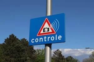 Verkehrsschild zur Geschwindigkeitskontrolle im Ausland – mögliche Bußgelder mit dem Mietwagen